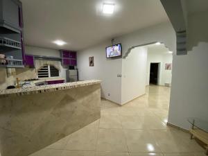 a large kitchen with purple cabinets and a tv on the wall at Residence Mont Vernon II - B in Cul de Sac