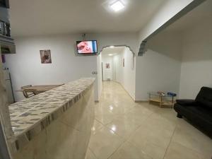a living room with a couch and a tv on a wall at Residence Mont Vernon II - B in Cul de Sac +4 photos