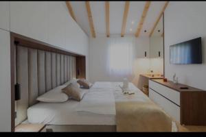 een slaapkamer met een groot bed en een televisie bij Villa Gold in Obrovac Sinjski +25 foto's