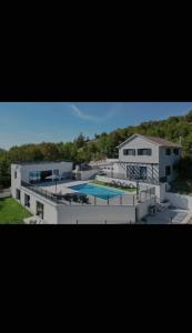 een groot wit gebouw met een zwembad erop bij Villa Gold in Obrovac Sinjski
