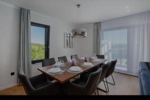 een eettafel met stoelen en een groot raam bij Villa Gold in Obrovac Sinjski