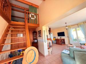 a living room with a staircase in a house at Au bord de la piscine pres de la plage in La Brée-les-Bains