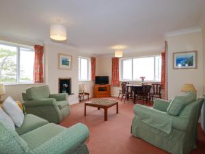 a living room with couches and a dining room at Godrevy View in St Ives