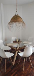 a dining room table with white chairs and a chandelier at Alojamientos Rías Baixas in Vilagarcia de Arousa