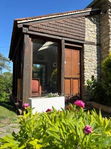 a small stone house with a large glass door at La cabane au fond du jardin in Villennes-sur-Seine +5 photos