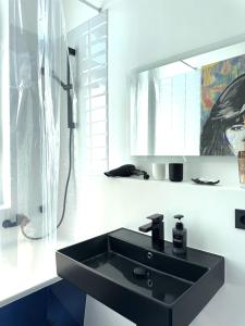 a bathroom with a black sink and a shower at Dein City Apartment - 2 Zi -Schick - Private Parking in Chemnitz