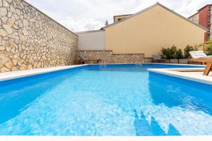 een zwembad met blauw water voor een gebouw bij Apartment DP in Pula