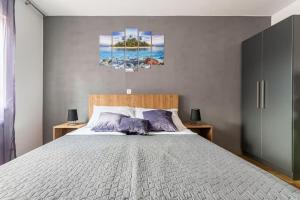 een slaapkamer met een groot bed met paarse kussens bij Apartment DP in Pula +20 foto's