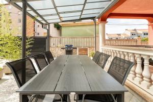 een houten tafel en stoelen op een balkon bij Apartment DP in Pula