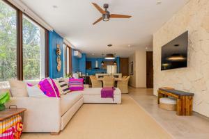 ein Wohnzimmer mit einem weißen Sofa und einem Deckenventilator in der Unterkunft Casa Jaguar Villa 1 in Playa del Carmen