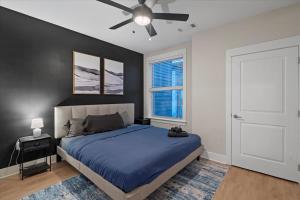 a bedroom with a blue bed and a ceiling fan at Upscale King 3BR Suite Mins to Uptown Charlotte in Charlotte