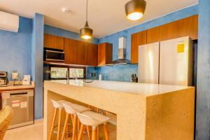 eine Küche mit einer Theke mit Hockern und einem Kühlschrank in der Unterkunft Casa Jaguar Villa 1 in Playa del Carmen