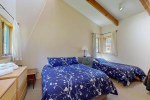 a bedroom with two beds and a desk and window at Loon's Landing in Sea Ranch