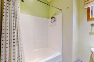 a bathroom with a shower curtain and a tub at Loon's Landing in Sea Ranch +7 photos