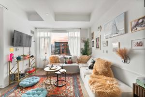 Una sala de estar con un sofá y un televisor. en South End Gem City Views Rooftop Pool, en Boston