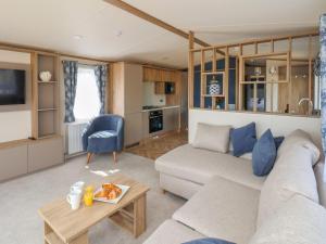 een woonkamer met een bank en een tafel bij Maple Lodge in Whitby