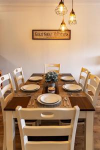 a dining room table with white chairs and a wooden table and chairsktop at Cozy Vista Condo by Avada Properties in Pigeon Forge +33 photos
