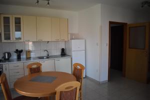 a kitchen with a wooden table and a small table and chairs at Apartman KiP in Zadar