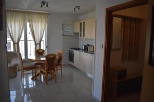 a kitchen and dining room with a table and chairs at Apartman KiP in Zadar