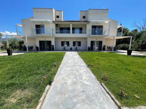 a large white house with a grassy yard at Villa Rodelia in Roda