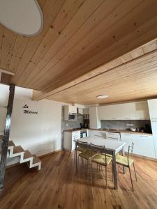 a kitchen and dining room with a table and chairs at Appartamenti la Muraca Family in Capizzone