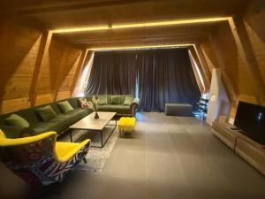 a living room with a green couch and a table at Vikendica Sofijina Luka in Slatina Varoš