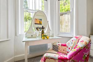 a room with a chair and a dressing table with a mirror at KGV Stays - Sant Bank City Apartment, 1 bed, modern, central, near beach in Bournemouth