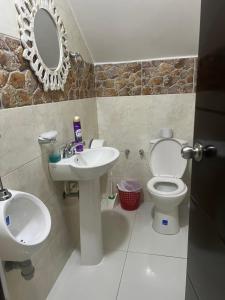 a bathroom with a sink and a toilet and a mirror at Finca Hotel Villa el Ocaso Huila in Rivera