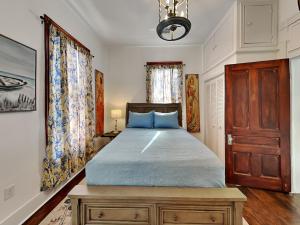 a bedroom with a bed with blue pillows at The Vintage Sea Turtle in Galveston +11 photos