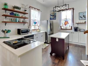 a kitchen with white counter tops and a refrigerator at The Vintage Sea Turtle in Galveston
