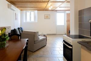 a kitchen and living room with a couch and a stove at Green Harmony in Tivat