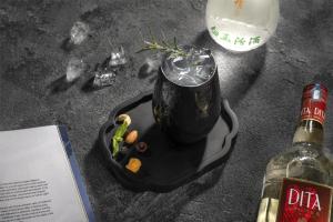 a drink in a black container next to a bottle of wine at Kempinski Hotel Chengdu-City Center in Chengdu