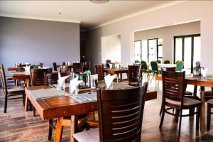 a dining room with wooden tables and chairs at Matholeng Gardens Guesthouse in Foso