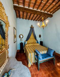 a bedroom with a bed and a blue chair at Villa Il Poggio in Sinalunga +63 photos