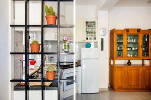 a kitchen with a shelf with potted plants and a refrigerator at Manzoni Apartment in Le Castella