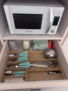 a microwave oven sitting on top of a drawer at Le Potager in Quartu SantʼElena