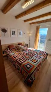 a bedroom with a bed with a colorful blanket on it at Vikendica Weekend story Tuzla in Gornja Tuzla