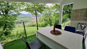 a table and chairs in a room with a view at Vikendica Weekend story Tuzla in Gornja Tuzla