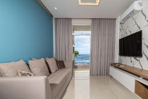a living room with a couch and a flat screen tv at Ingleses Park Hotel in Florianópolis