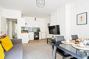 a living room with a dining room table and a kitchen at KGV Stays - Sant Bank City Apartment, 1 bed, modern, central, near beach in Bournemouth