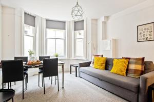 a living room with a couch and a table at KGV Stays - Sant Bank City Apartment, 1 bed, modern, central, near beach in Bournemouth