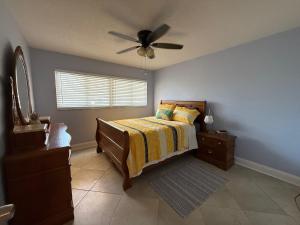 a bedroom with a bed and a ceiling fan at Treasure Island Beach, FL Waterfront Condo Located Steps away from the Intracoastal Waterway in St Pete Beach