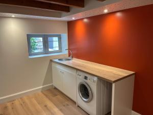 a laundry room with a washing machine and a sink at Appartement Quartier Jardin Public in Parthenay
