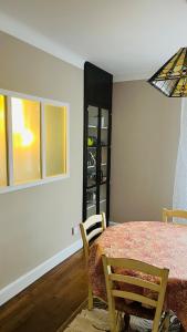 a dining room with a table and chairs and a window at Appartement Quartier Jardin Public in Parthenay +8 photos