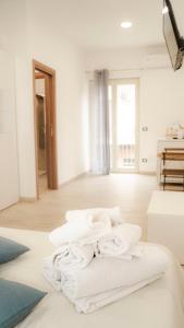 a pile of towels sitting on the floor of a room at Gira, vota e furria in Giardini Naxos