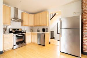 ポートランドにあるStay Portland - Scandinavian Loft - Local Espresso & Boutiquesのキッチン(ステンレス製の冷蔵庫、木製キャビネット付)