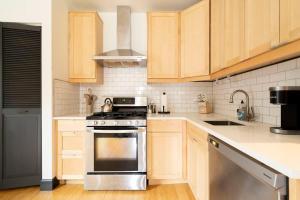 ポートランドにあるStay Portland - Scandinavian Loft - Local Espresso & Boutiquesのキッチン(木製キャビネット、ステンレス製オーブン付)