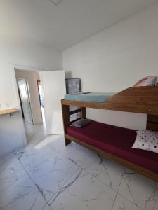 a bedroom with a bunk bed and a tiled floor at Casa praia in Itajubá
