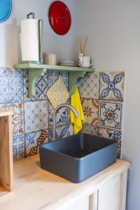 a black sink in a kitchen with tiles at Palazzo San Biagio in Viterbo