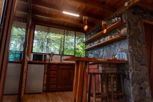 a kitchen with a counter and a stone wall at Cabaña "Los Cedros", Sumak Cabañas in Baeza